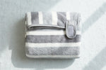 Gray striped pet bath robe folded flat showing velcro strap